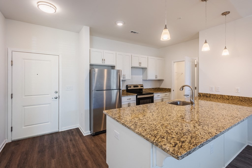 a kitchen with a granite counter top and stainless steel refrigerator