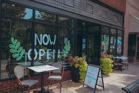 a restaurant with a now open sign in the window
