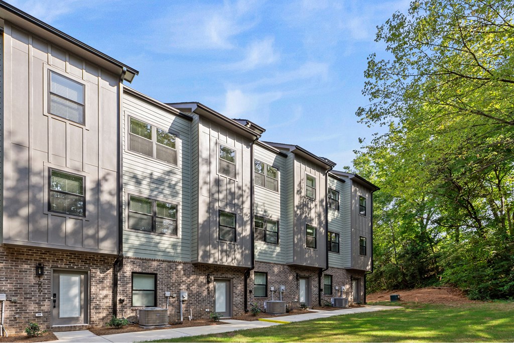 A row of townhouses with a green tree in the background.