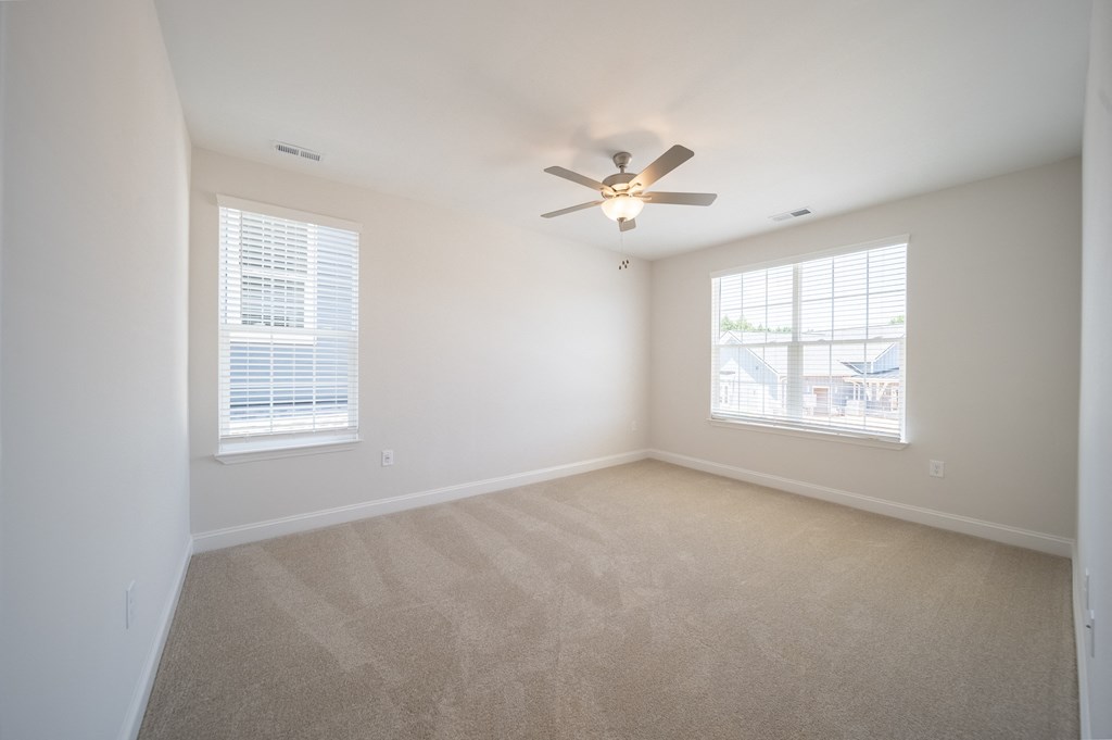 a bedroom with two windows and a ceiling fan at Landon Green Artisan Cottages Apartments, Hickory
