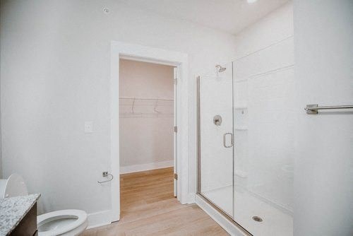 a white bathroom with a shower and a toilet