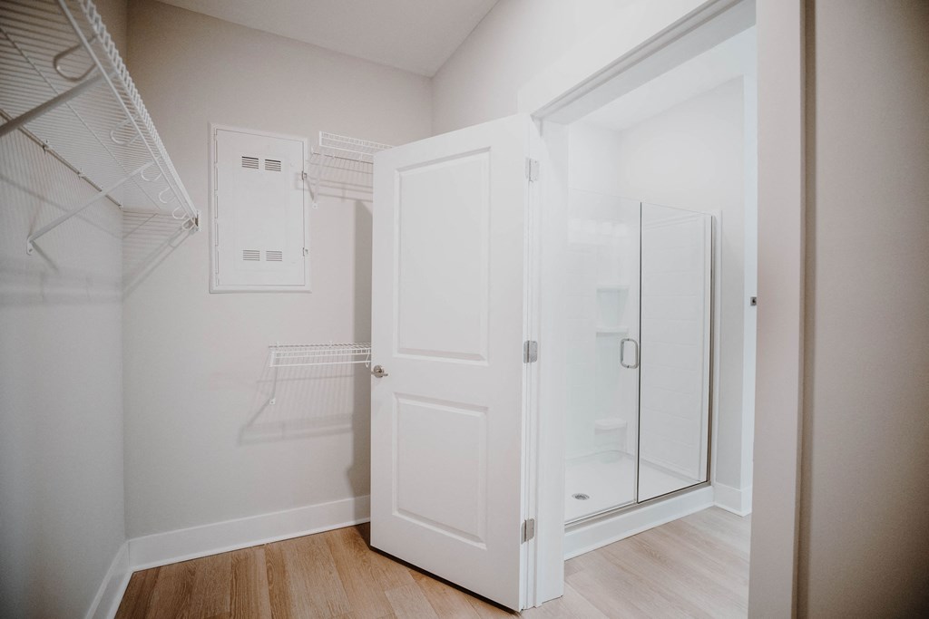 a walk in closet in a bedroom with a mirrored closet door