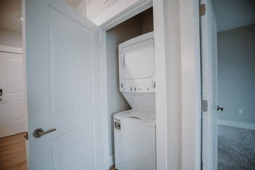 a white washer and dryer in a room with a door