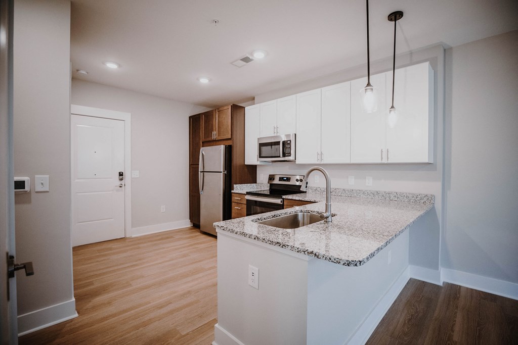 a kitchen with white cabinets and a granite counter top