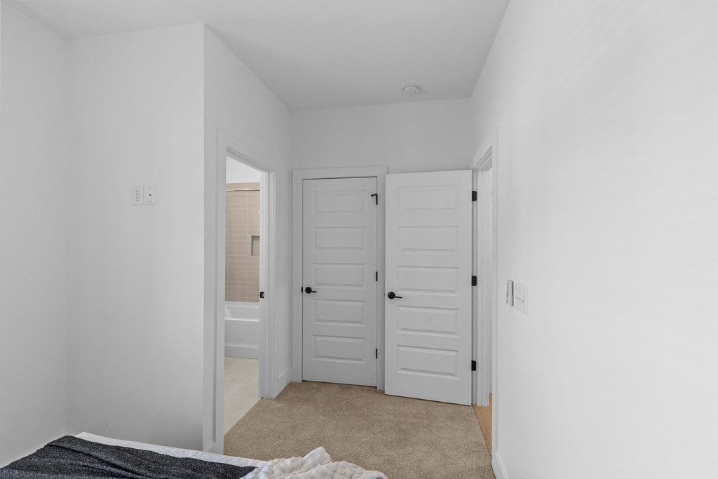 a bedroom with two closets and a bed and a door to a bathroom at The Collection Charlotte in Charlotte, NC, 28205