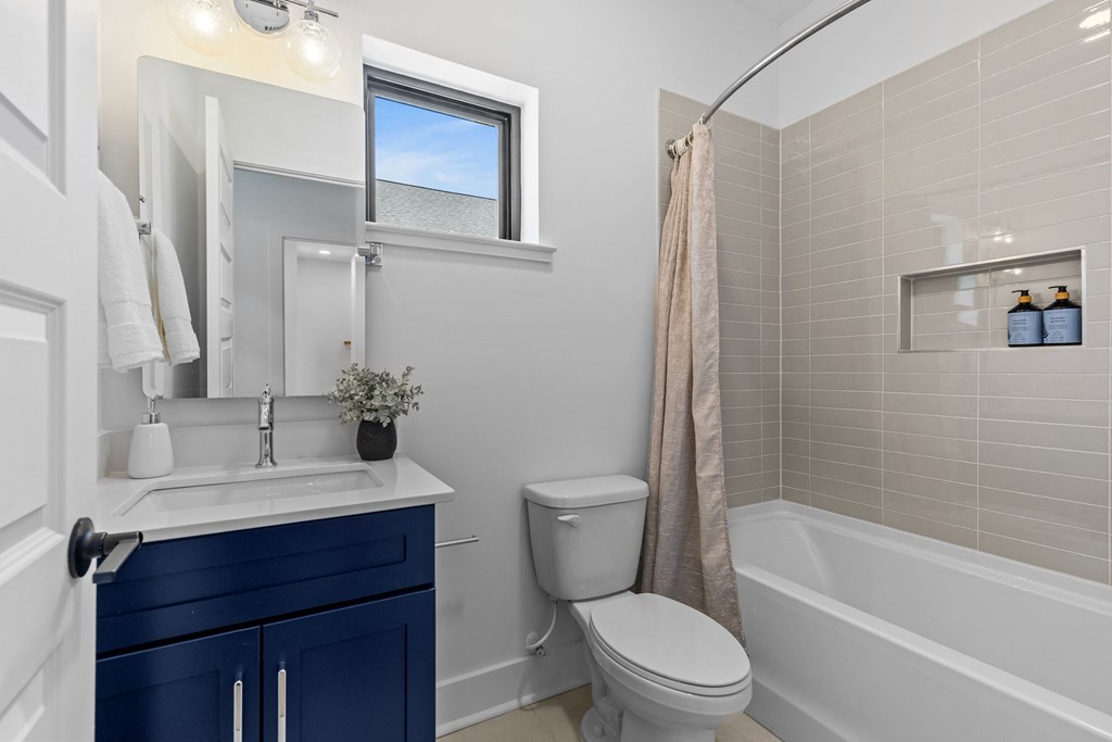 a bathroom with a toilet sink and tub and a window at The Collection Charlotte in Charlotte, NC, 28205