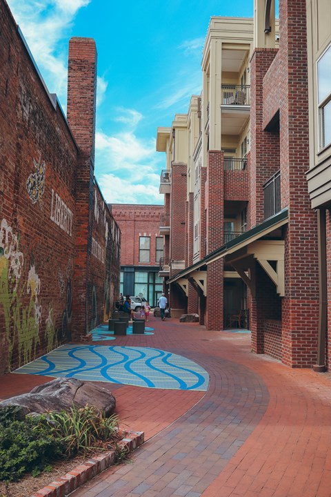 a city street with brick buildings and a blue mural on the ground