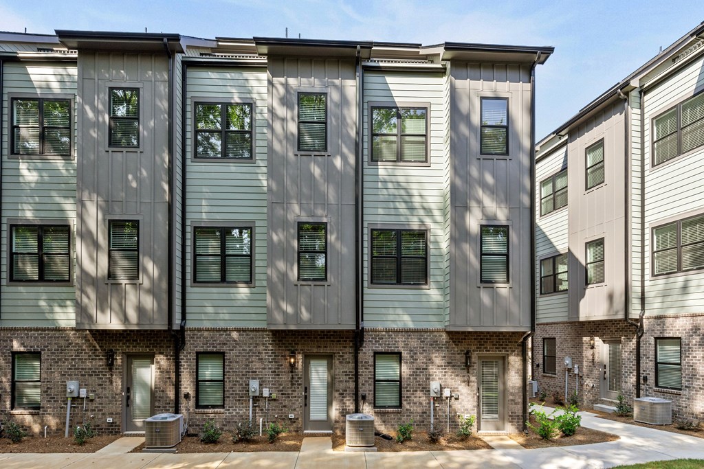 A row of modern townhouses with grey and beige exteriors.