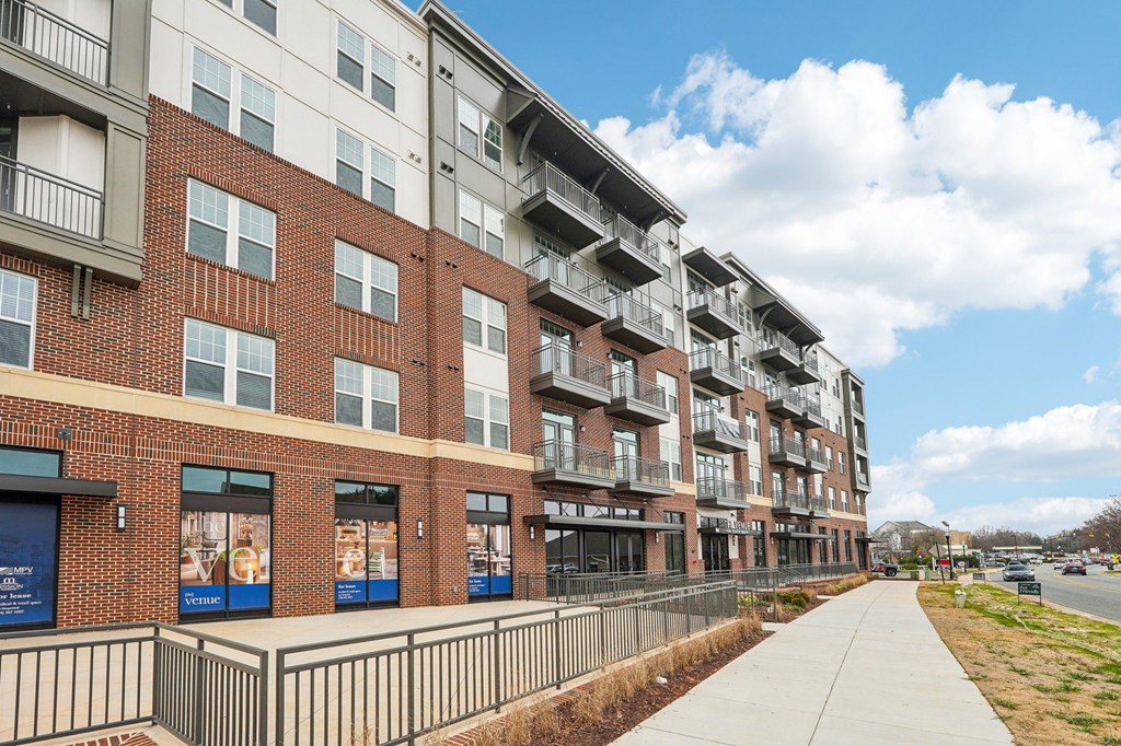 A long building with a fence in front of it.