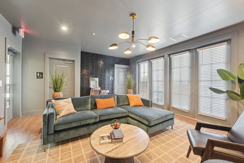 A living room with a green couch and a wooden coffee table.