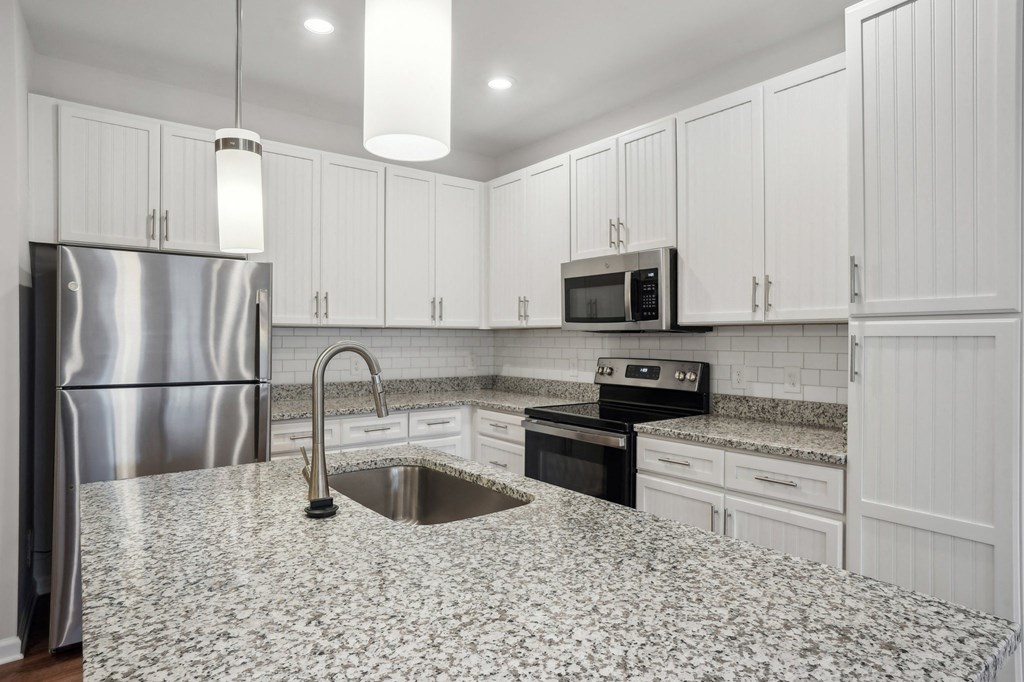A kitchen with a granite countertop and stainless steel appliances.
