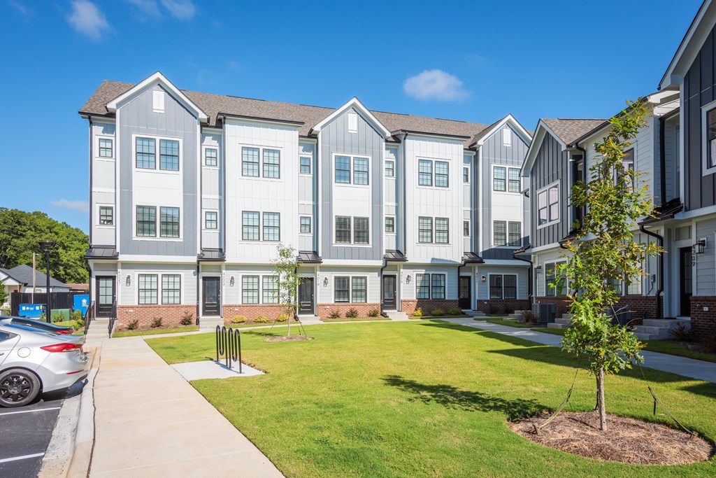 A large, modern apartment complex with a well-maintained lawn in front.