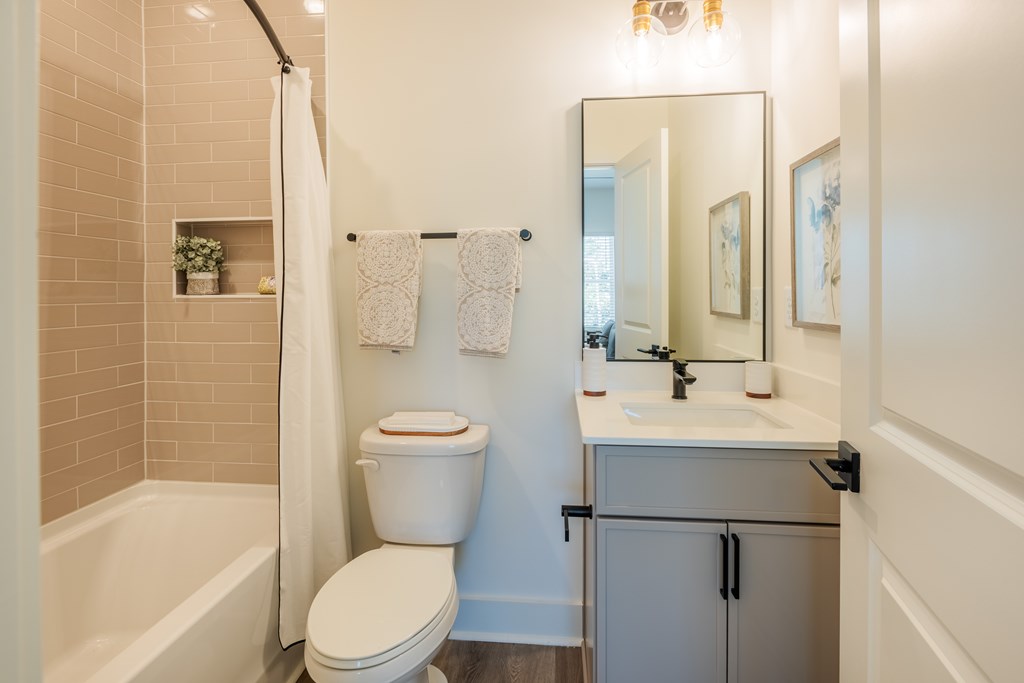 A white toilet sits next to a bathtub in a bathroom.