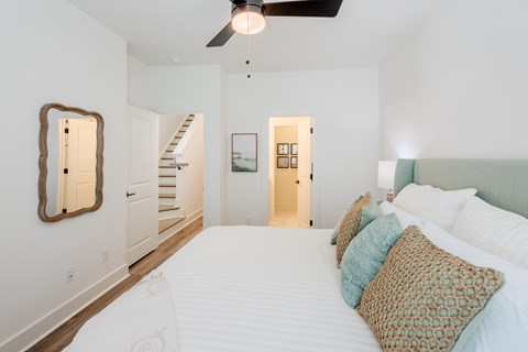 A bedroom with a large bed and a ceiling fan.