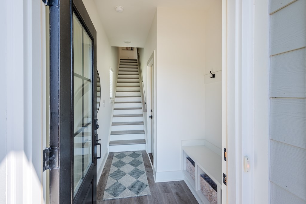 A hallway with a staircase and a bench.