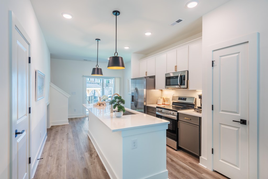 A kitchen with a white island and a microwave above it.