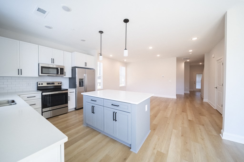 a kitchen with white cabinets and a large island with a white countertop at Landon Green Artisan Cottages Apartments, Hickory, NC, 28601