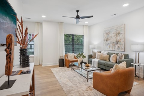 A living room with a brown chair and a green couch.