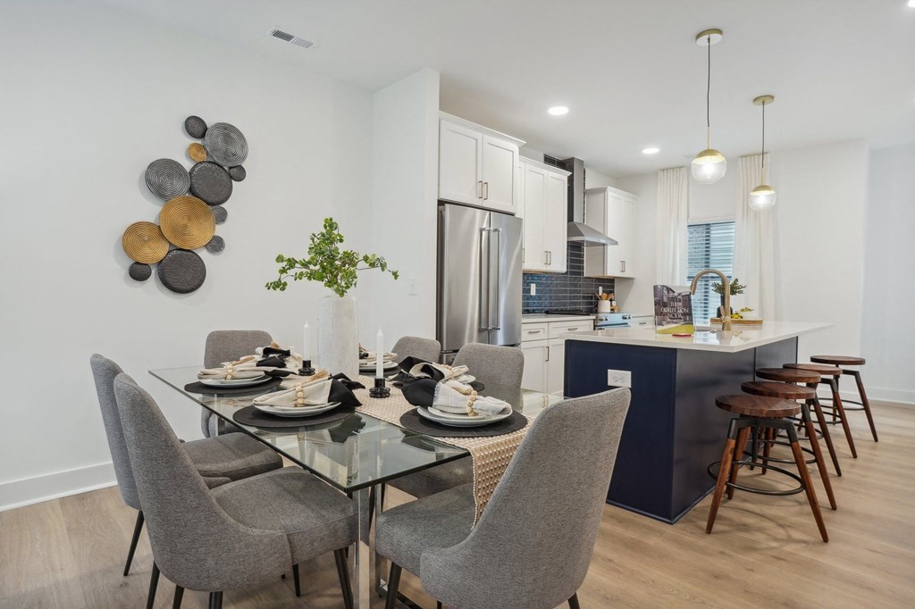an open kitchen and dining room with a glass table and chairs at The Collection Charlotte in Charlotte, NC, 28205