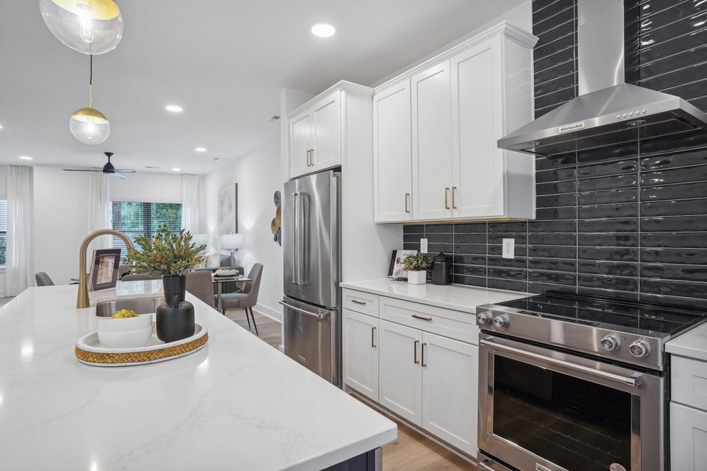 a white kitchen with stainless steel appliances and white counter tops at The Collection Charlotte in Charlotte, NC, 28205