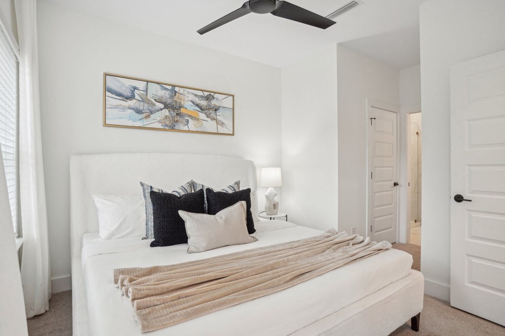 a bedroom with a white bed and a ceiling fan at The Collection Charlotte in Charlotte, NC, 28205
