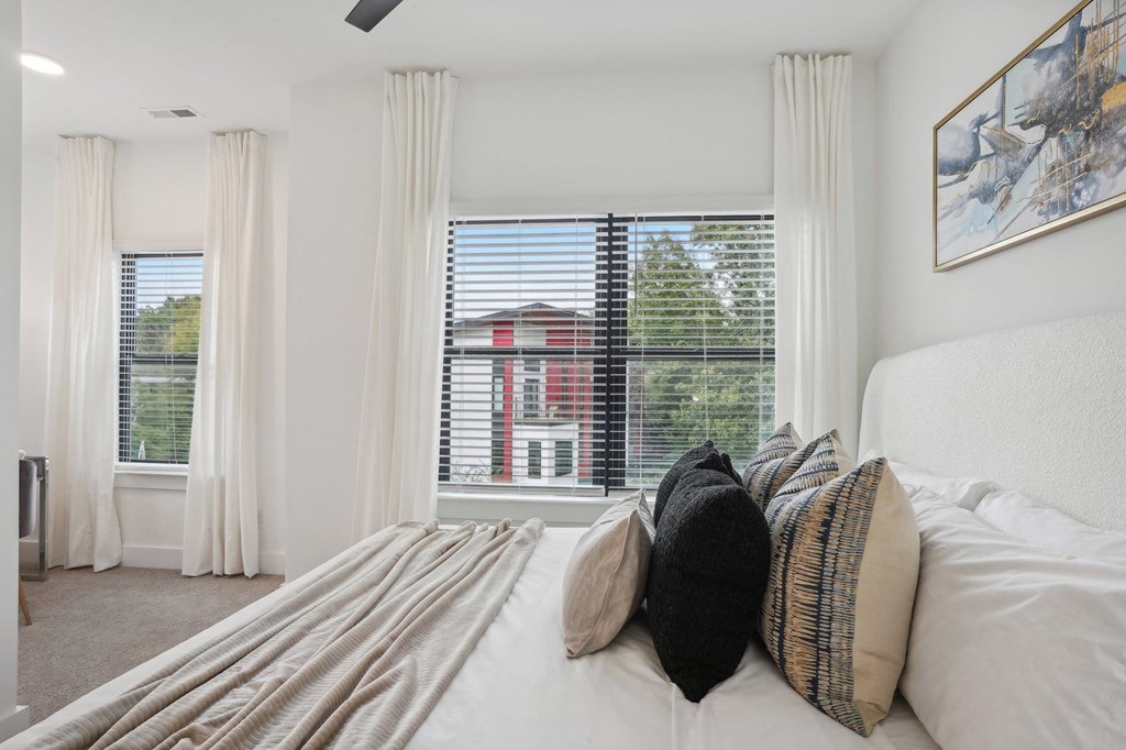 a bedroom with a large window and a bed with pillows at The Collection Charlotte in Charlotte, NC, 28205