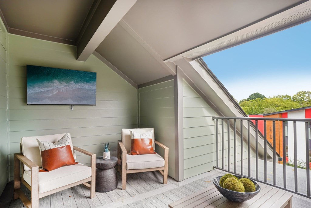 a balcony with two chairs and a table and a window at The Collection Charlotte in Charlotte, NC, 28205