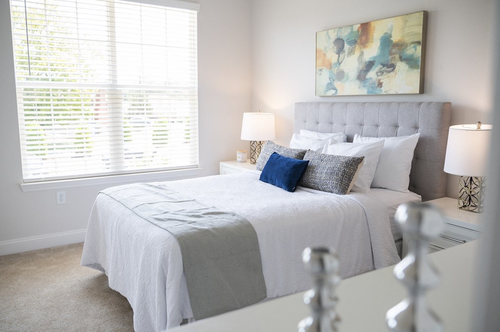 a bedroom with a large bed and two windows at Landon Green Artisan Cottages Apartments, North Carolina, 28601