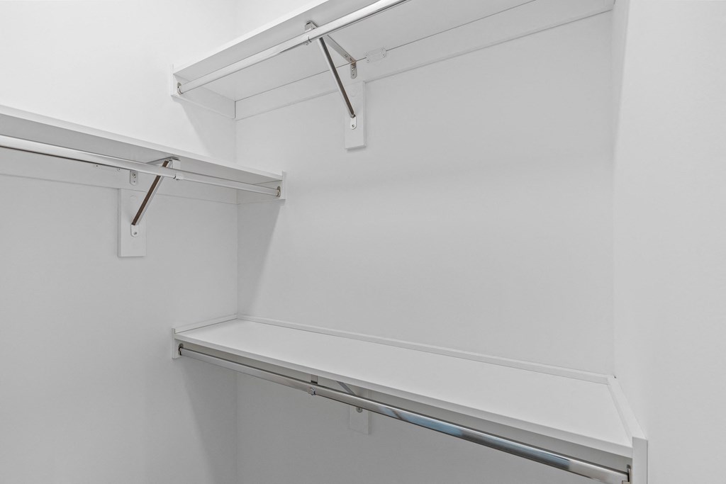 a walk in closet with a white wall and a white shelf at The Collection Charlotte in Charlotte, NC, 28205