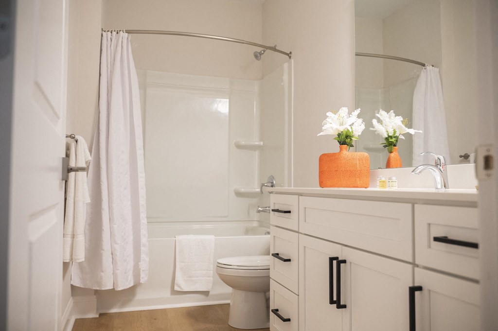 a bathroom with a white toilet next to a white bathtub at Landon Green Artisan Cottages Apartments, Hickory, NC, 28601
