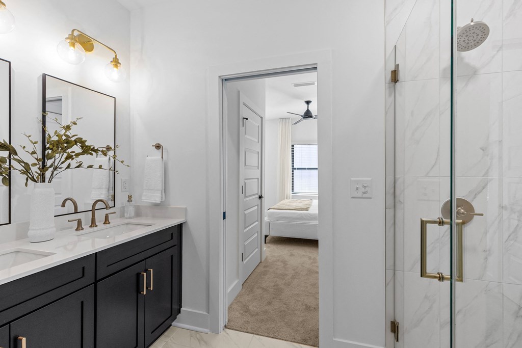a bathroom with a shower and a sink and a mirror at The Collection Charlotte in Charlotte, NC, 28205