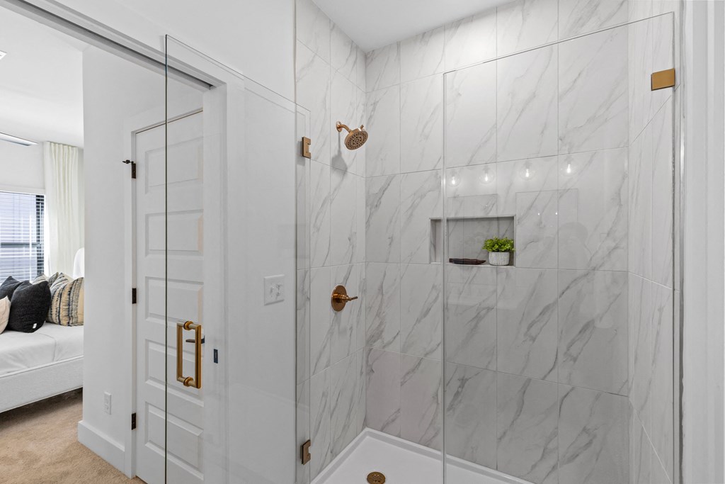 the master bathroom has a large shower with marble tile and a glass door at The Collection Charlotte in Charlotte, NC, 28205