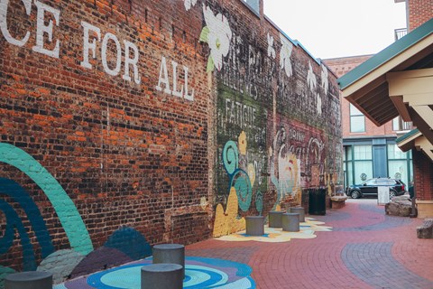 the side of a brick building with graffiti on it