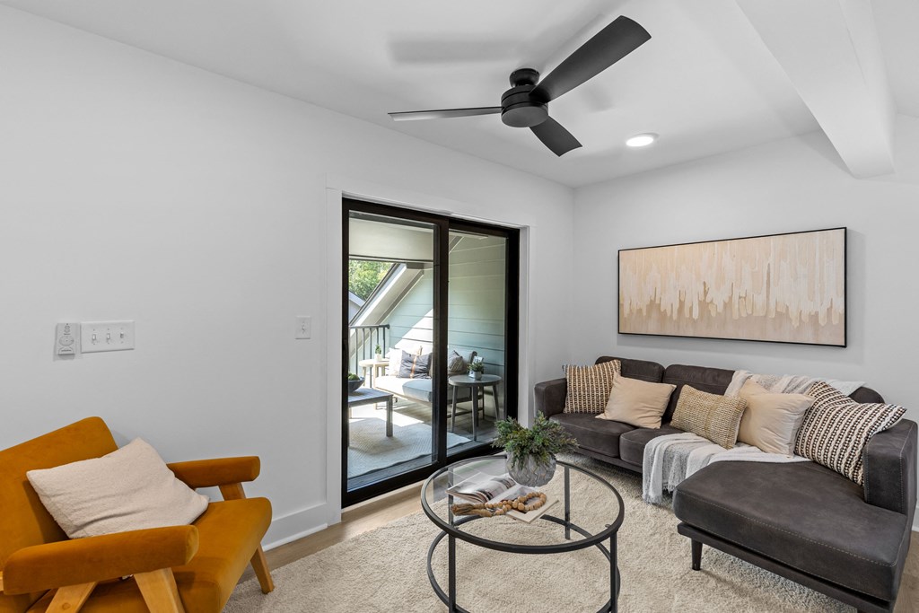 a living room with a ceiling fan and a sliding glass door to a patio at The Collection Charlotte in Charlotte, NC, 28205