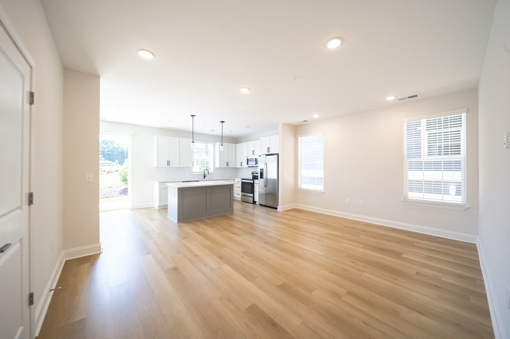 a kitchen and living room with hardwood floors and white walls at Landon Green Artisan Cottages Apartments, Hickory, NC
