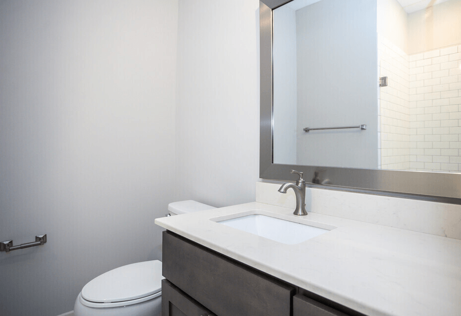 A white toilet sits next to a sink in a bathroom.