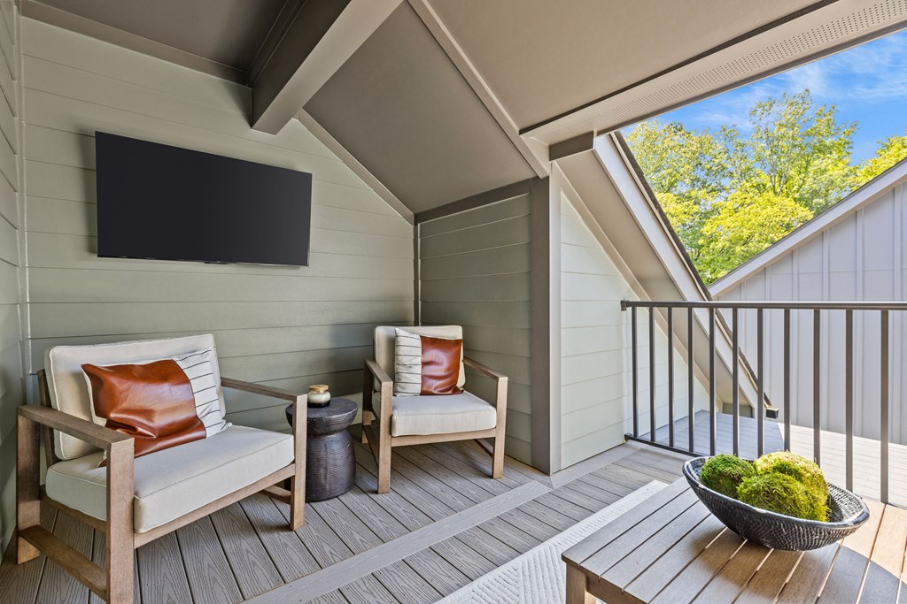 a porch with two chairs and a table and a television at The Collection Charlotte in Charlotte, NC, 28205