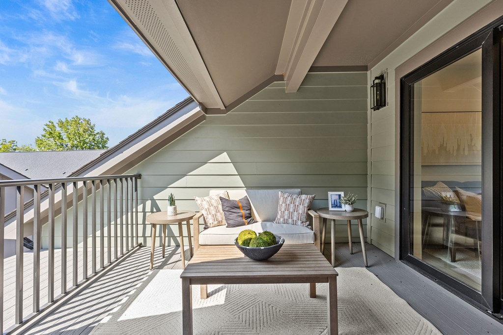 a balcony with a couch and a table with a bowl of fruit at The Collection Charlotte in Charlotte, NC, 28205