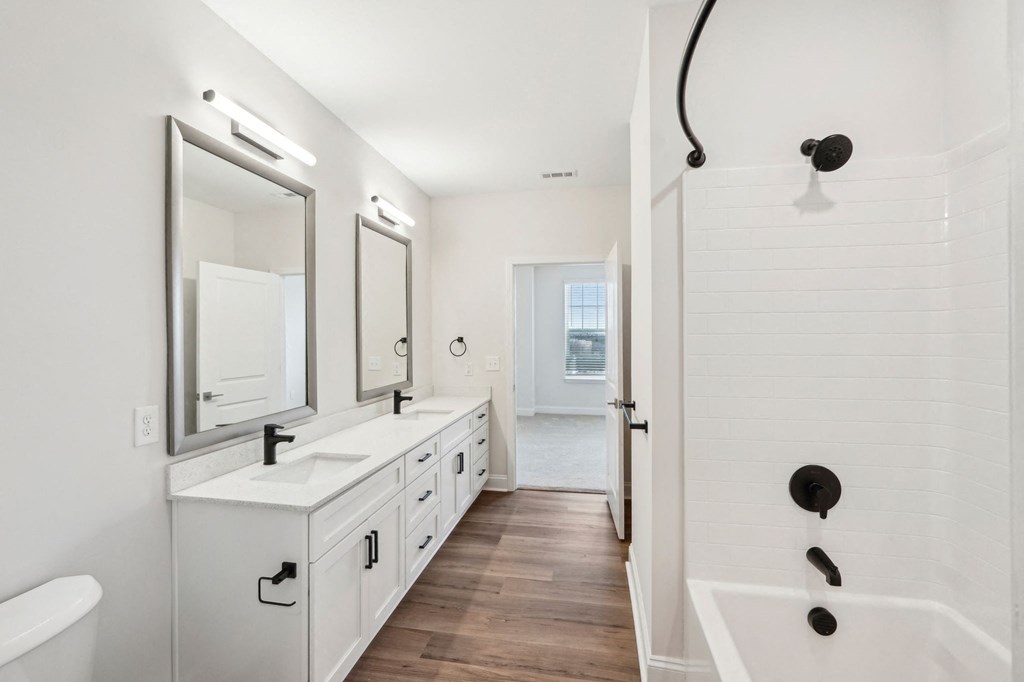 A white bathroom with a white tub and sink.