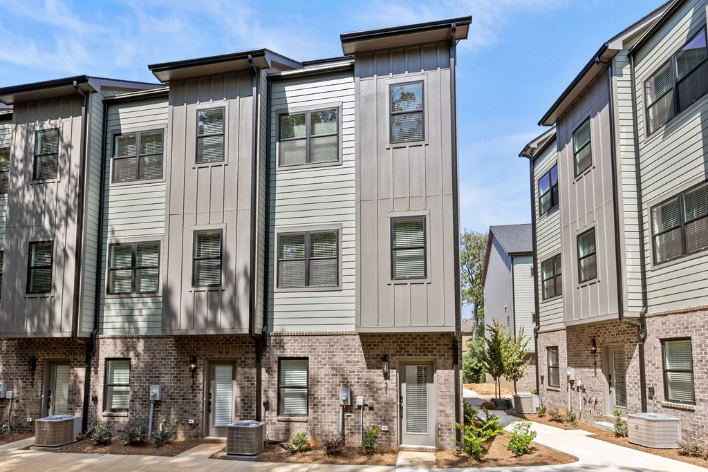 A row of modern townhouses with grey and beige exteriors.