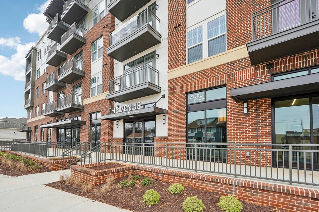 The Venue is a modern building with a red brick facade and a balcony on the second floor.