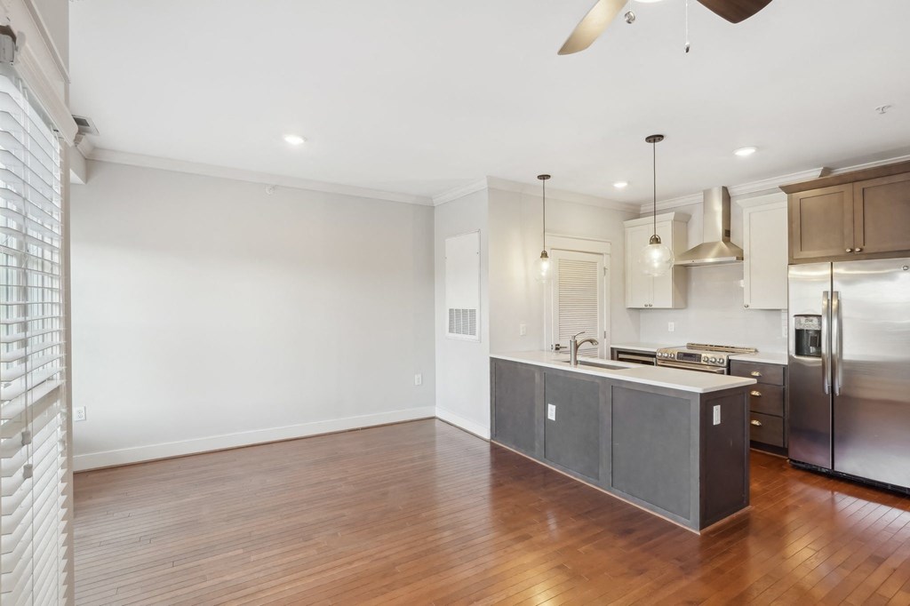 A kitchen with a wooden floor and stainless steel appliances.