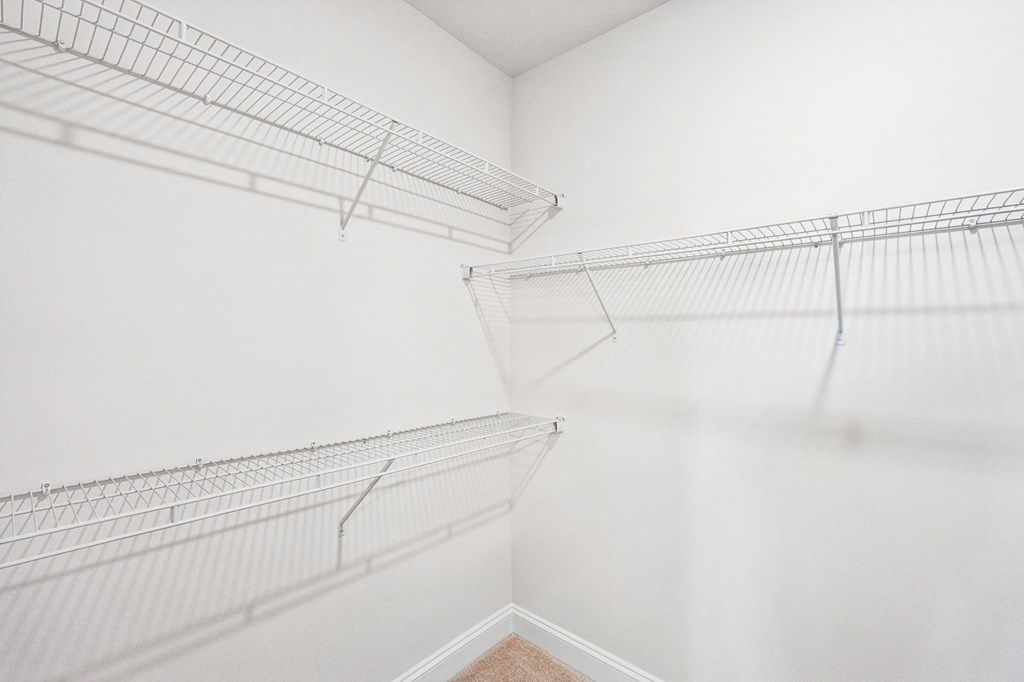 Empty wire shelving in a white room.