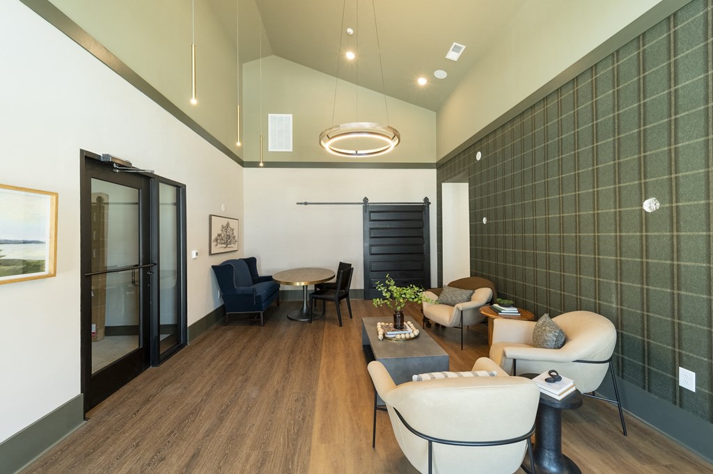a lounge area with couches chairs and a coffee table with a vase of flowers at Landon Green Artisan Cottages Apartments, Hickory, NC, 28601