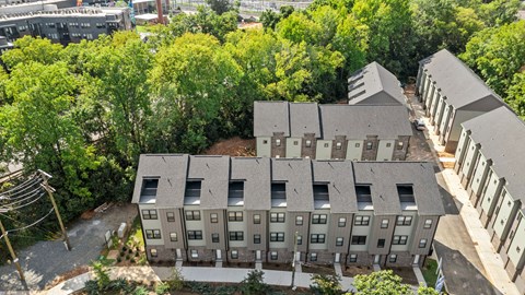 A large grey building surrounded by trees.
