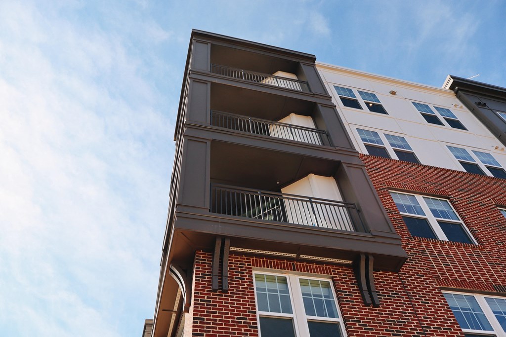 A red brick building with a balcony on the second floor.