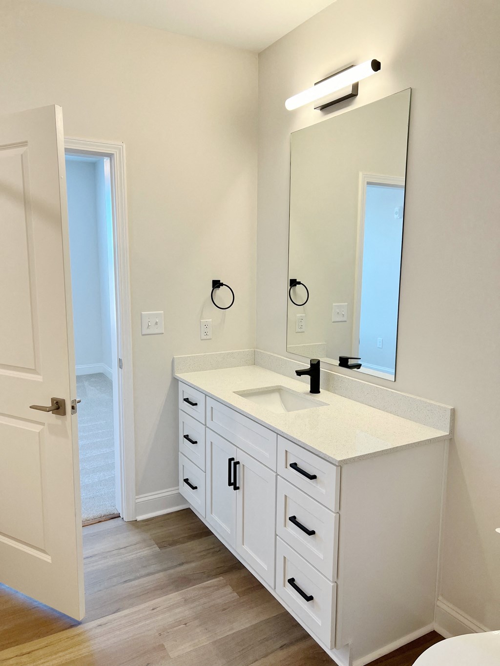 A white bathroom with a sink and mirror.