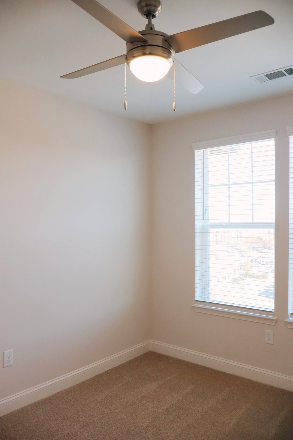 A room with a ceiling fan and a window.