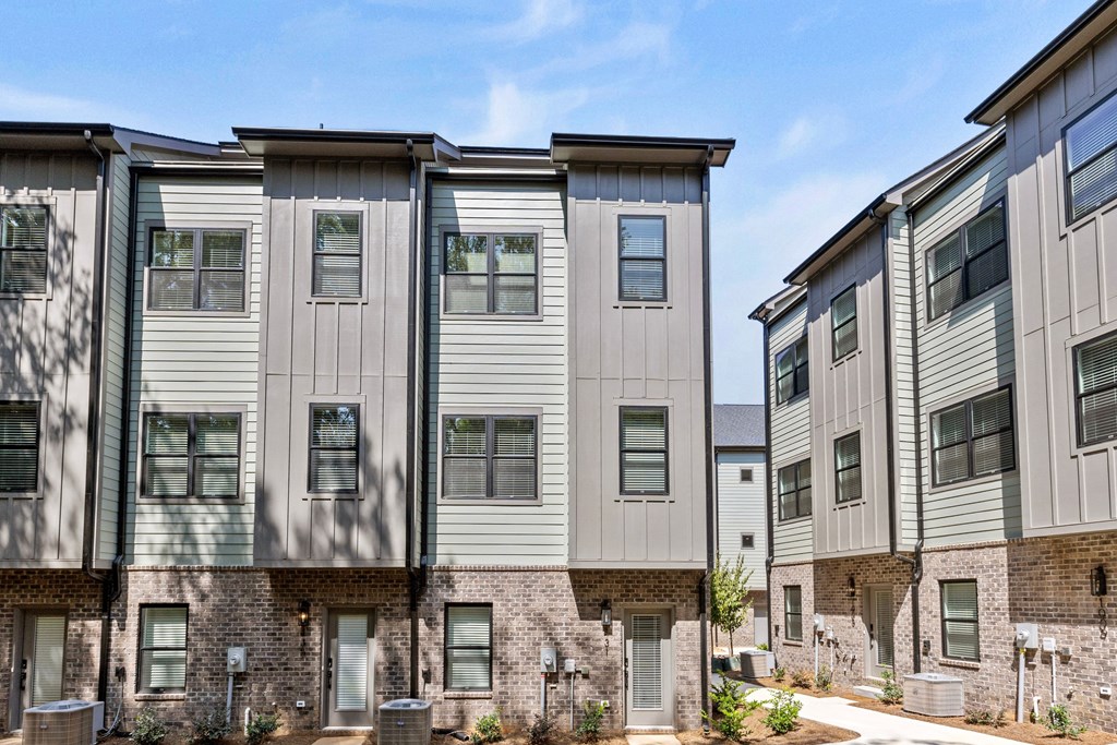 an apartment building with white siding and a brick facade at The Collection Charlotte in Charlotte, NC, 28205