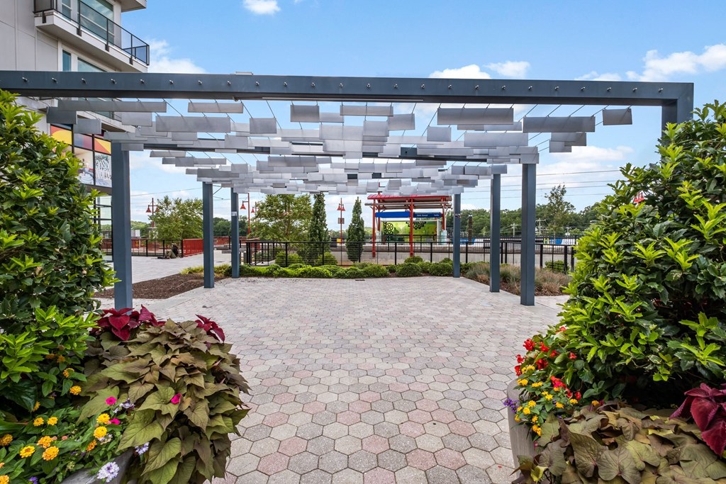 a courtyard with a pergola and plants on either side of it at The Collection Charlotte in Charlotte, NC, 28205
